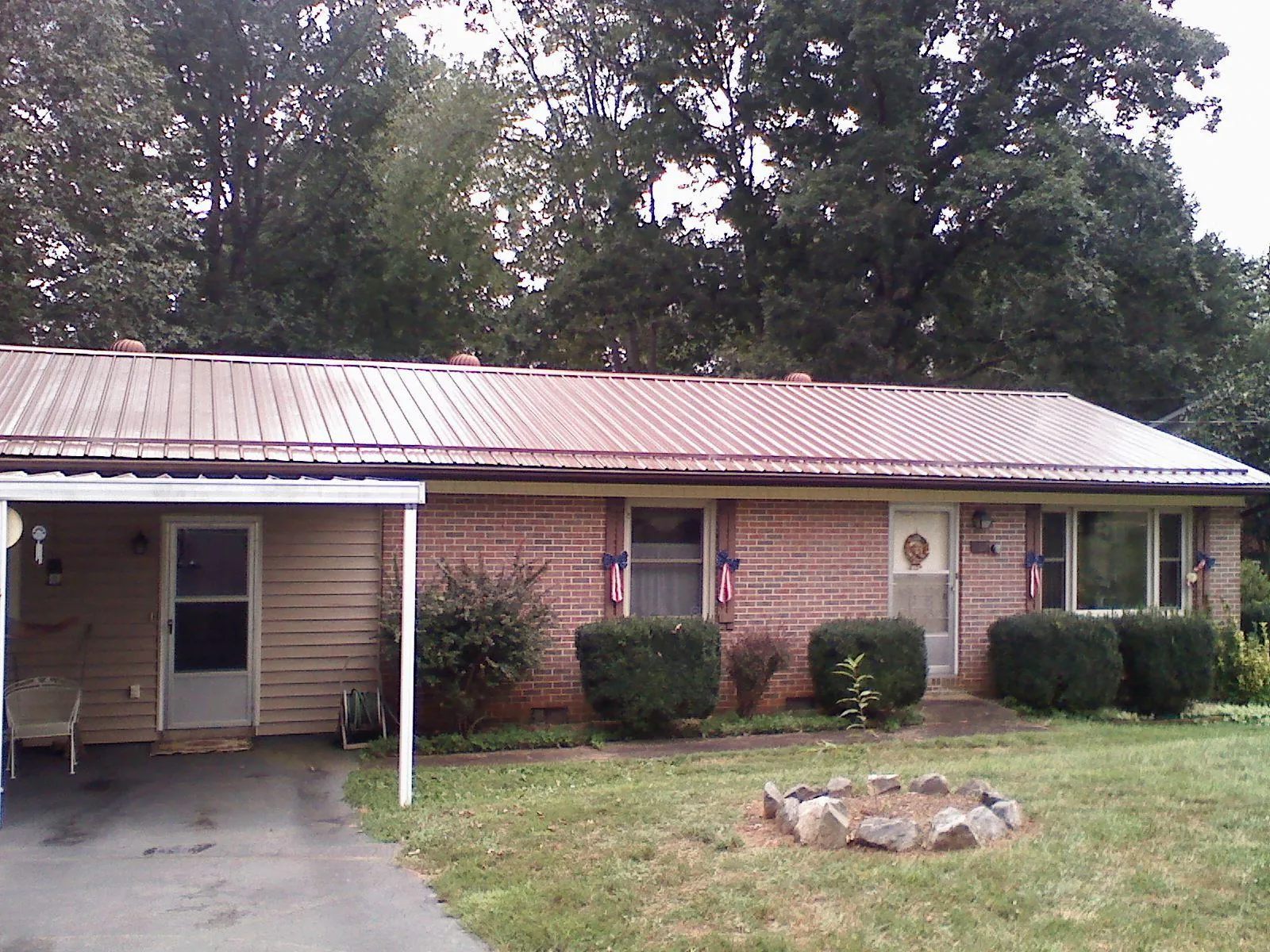 Bronze metal roof and carport on a brick ranch home — Roof Repair work by our crew in Hague